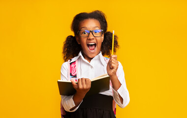 Excited Black Schoolgirl Holding Pencil Having Idea Standing, Studio Shot