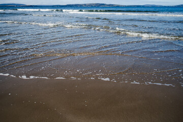 Fototapeta na wymiar pristine beach in Tasmania with deep blue ocean and dark golden sand