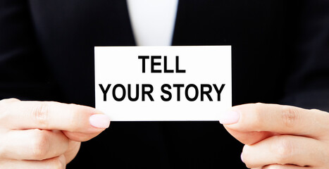 The businessman puts his card in his pocket with the inscription TELL YOUR STORY.