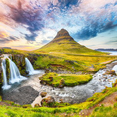 Dramatic view on Kirkjufellsfoss waterfall  near Kirkjufell mountain at sunset