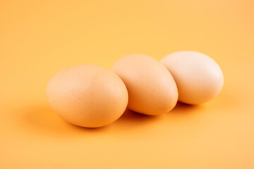 Three eggs on yellow background