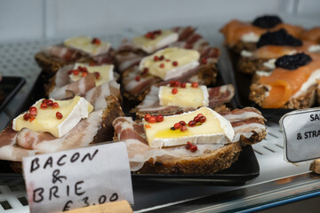 Brie cheese with bacon appetizer for aperitif. Italian antipasti