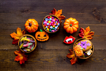 Halloween holiday background with pumpkins, cookies and autumn leaves, top view