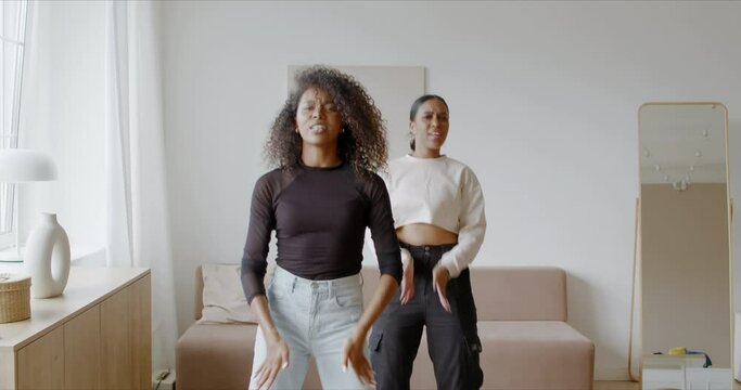 Two African-American Black girls recording trendy dance moves for social media account