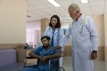 Obraz premium The doctor encourages the patient in the wheelchair in the hospital