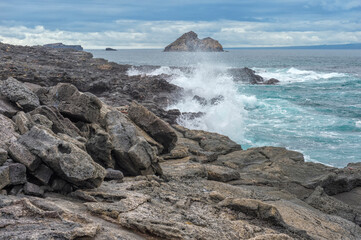 Fototapeta na wymiar Waves breaking on the coast of Chinese Hat Island off Santiago Island, Galapagos, Ecuador, Unesco World Heritage Site