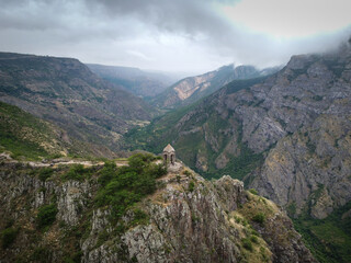 Aerial Drone view of Small chapel in the top of the mountain, surrounded by high mountain range, tourists walks around