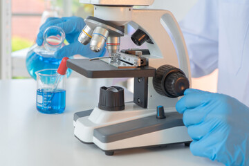 Scientist working on colorful test tube to analysis and develop vaccine of covid-19 virus in lab or...