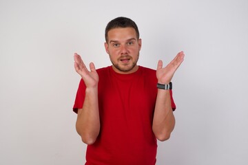 Surprised terrified Young handsome Cucasian man Gestures with uncertainty, stares at camera,...