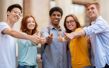Students Gesturing Thumbs Up Approving University Standing Outdoor