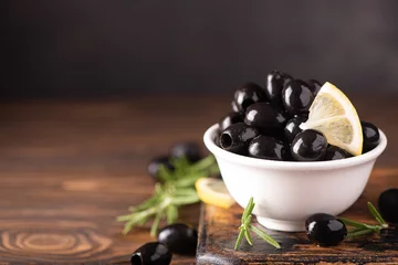 Foto op Plexiglas pitted black olives with lemon in a white bowl © Ольга Гагарова