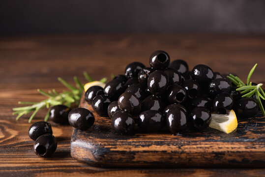 Pitted Black Olives On Wooden Board