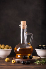 Fototapeta na wymiar olive oil in a glass bottle with olives, herbs and spices