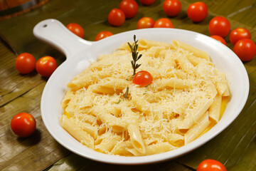 Bucatini pasta in garlic sauce, Parmesan cheese and cherry tomato.