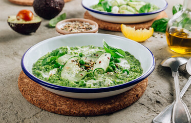 Cold green soup Gazpacho with cucumber, green peas, basil leaves and avocado.