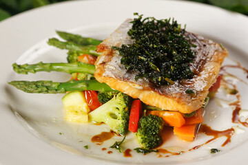 Smoked salmon with chimichurri and vegetable garnish with pumpkin, carrot, broccoli and asparagus.