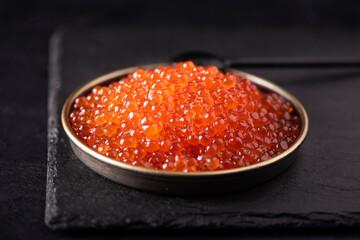red large salted caviar in a small black plate