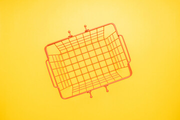Shopping concept illustration with an empty shopping basket on yellow background
