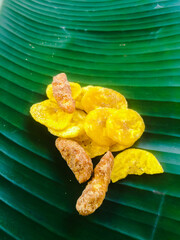 Banana chips with jaggery coated banana chips on a banana leaf.