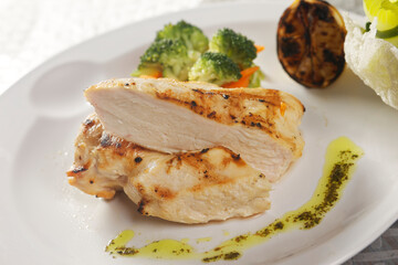 Roasted chicken breast served with a lettuce salad garnished with broccoli, carrot, pumpkin, and lemon juice.
