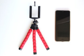 Mobile phone and tripod on white background.Smart phone new technology dedicated for live streaming. Blogger equipment.