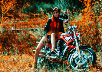 Plakat red-haired beautiful girl and motorcycle outdoors