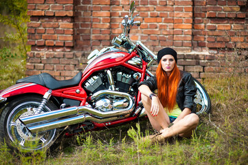 Obraz na płótnie Canvas red-haired beautiful girl and motorcycle outdoors