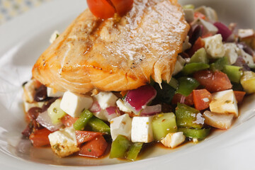 Roasted fillet of tilapia fish accompanied by vegetable garnish with pumpkin, fresh cheese, tomato...