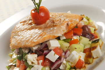 Roasted fillet of tilapia fish accompanied by vegetable garnish with pumpkin, fresh cheese, tomato and pepper seasoned with vinaigrette.