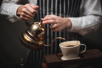 Hand drip coffee filter, barista pouring hot water on roasted coffee ground with filter