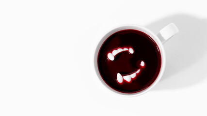 White cup with fake blood and toy vampire teeth on white background with copy space. Creative Halloween minimal concept