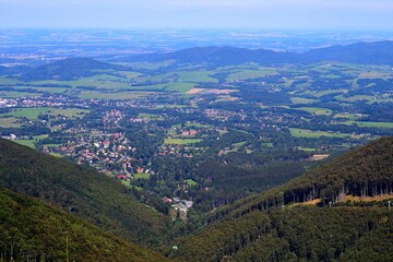 Obraz premium view from the Pusteven ridge in the Beskydy mountains to the valley with a mountain town and an opening plain to the north