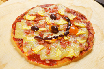 Traditional Italian pizza with tomato sauce, ham, pineapple and pepperoni.
