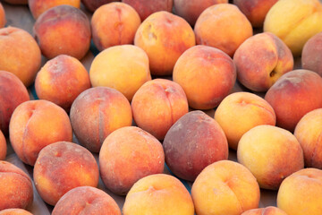 Natural organic peach on the market shelf as a background.