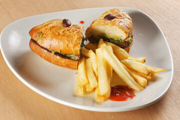 Beef baguette with tomato, lettuce, avocado and dressings accompanied by french fries.