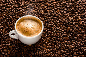 Cup with coffee on the background of coffee beans