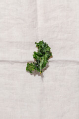 Veggie kale chips with pepper and olive oil on textile napkin top view.Low-carb and gluten free vegetable crisps snack