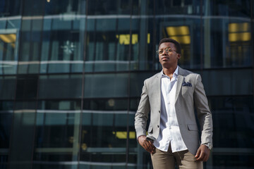 Young attractive black man in a business suit against the background of the city.