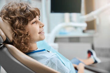 Lovely kid sitting in a dentists office ready for a check-up