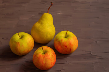 Four fresh fruit lie on a dark grey background