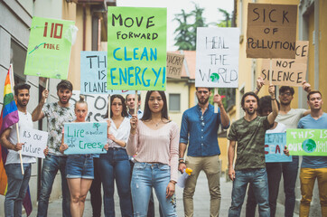 Public demonstration on the street against global warming and pollution. Group of multiethnic people making protest about climate change and plastic problems in the oceans - obrazy, fototapety, plakaty