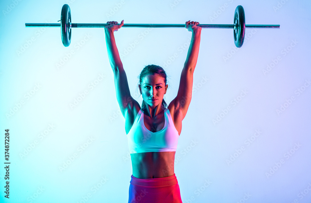 Wall mural woman training with barbells in the gym