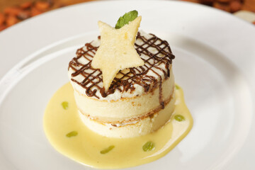 Vanilla dessert with custard, chocolate and star-shaped biscuit.