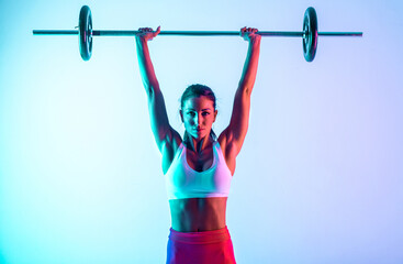 Woman training with barbells in the gym