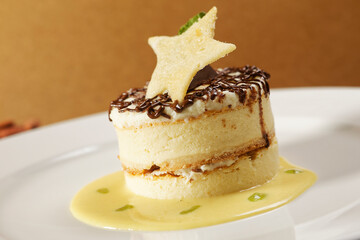 Vanilla dessert with custard, chocolate and star-shaped biscuit.