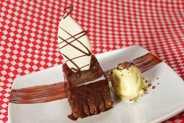 Walnut dessert with melted chocolate accompanied by vanilla ice cream and white chocolate.