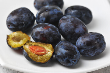 juicy ripe black and blue plums on a plate