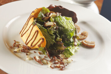 Lettuce salad with walnut, biscuit and chocolate.