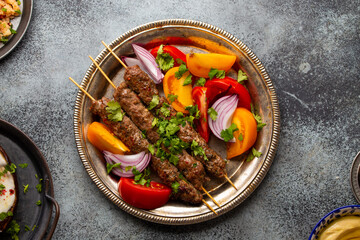 Delicious meat kebab with fresh vegetable salad served on rustic plate, traditional Middle eastern dish. Tasty and healthy meal of Arab or Mediterranean cuisine, from above
