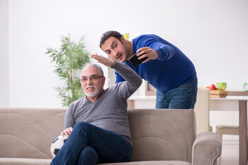 Obraz premium Father and son watching soccer on tv